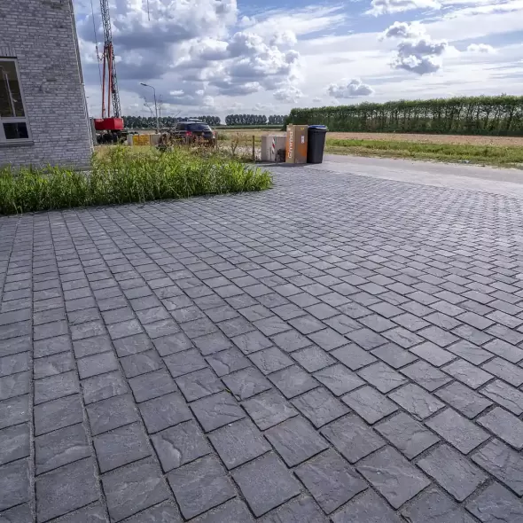 Tamsiai pilkos bazalto spalvos akmens imitacijos betoninių trinkelių danga namo kieme