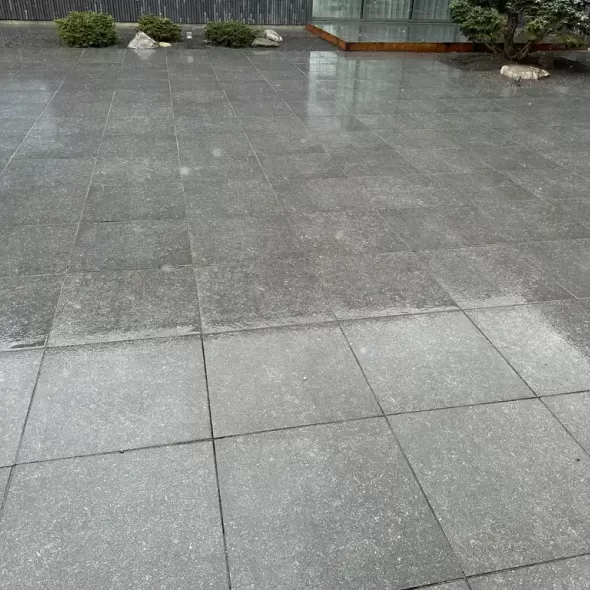 Tamsiai pilkos antracito spalvos Geokeramika Geoceramica suklotų lauko plokščių danga erdviame namo kieme