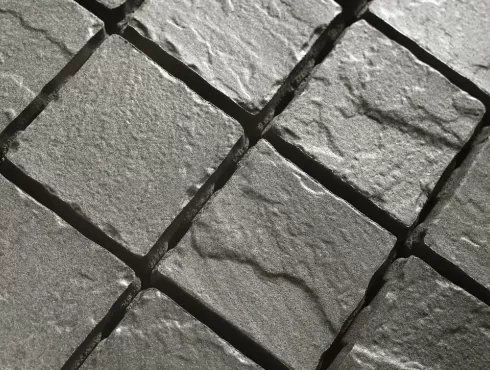 Juodo bazalto akmens imitacijos betoninių trinkelių paviršius iš arti